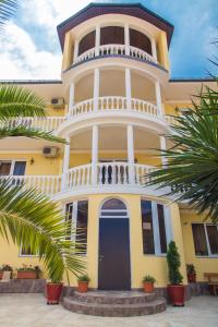 a large yellow house with a blue door at Orange House Guest House in Adler