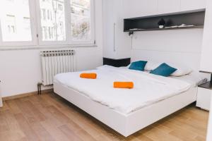 1 dormitorio con 1 cama blanca con almohadas de color naranja y azul en Modern 2BDR apartment-CATHEDRAL VIEW-BEST LOCATION, en Sarajevo