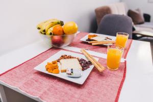 una mesa con un plato de comida y zumo de naranja en Modern 2BDR apartment-CATHEDRAL VIEW-BEST LOCATION, en Sarajevo