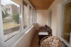 a small balcony with a chair and a window at Karolina in Nida