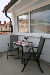 皮兰Apartments Igor的阳台配有桌椅和窗户