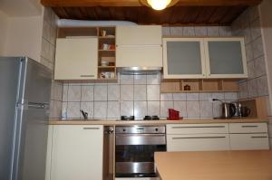 a kitchen with white cabinets and a stainless steel refrigerator at Karolina in Nida