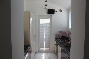 a kitchen with white walls and a door leading into a kitchen at Desiderio D'Ammore in Corbara