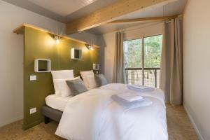 a bedroom with a large white bed and a window at Domaine Spalazen Nature in Palazinges