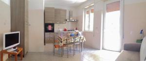 スカウリにあるCasa sul Monte d'Oroのキッチン(テーブル、椅子、テレビ付)