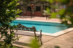 un banco sentado junto a una piscina en RVHotels Hotel Palau Lo Mirador en Torroella de Montgrí