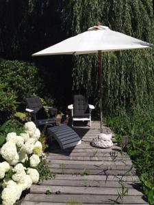 a patio with two chairs and an umbrella at B&B De Koraal in Emmen