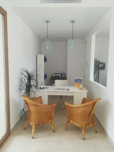 a office with a desk and two chairs in a room at Apartamentos Villa Primera in Cala Figuera