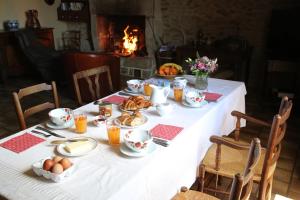 a table with food and eggs on it with a fireplace at Chambre d'hôte Courtoux in Saint-Denis-sur-Sarthon