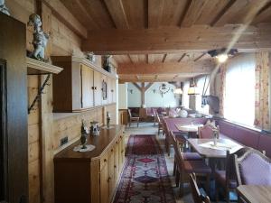 a restaurant with wooden walls and tables and chairs at Ferienhof zur Sonne in Tux