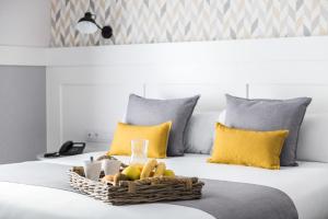 a basket of fruit on a bed with yellow pillows at BYPILLOW Velázquez 45 in Madrid