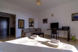 a living room with a bed and a couch at Gerakari Suites in Agia Pelagia