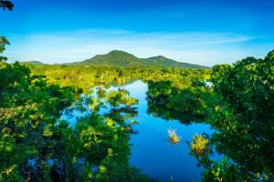 uma vista aérea de um rio com árvores e montanhas em Kulu Safaris - All Inclusive em Yala