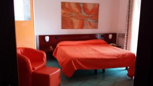 1 dormitorio con 1 cama roja y 1 silla en Hotel Annabelle en Ischia