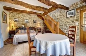 ein Schlafzimmer mit einem Bett und einem Tisch in einem Zimmer in der Unterkunft A la Ferme de Kervihern in Locoal-Mendon