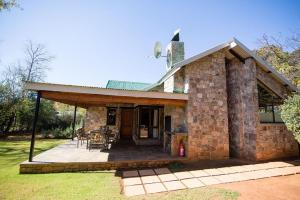 a large stone house with a patio at Big Oak Cottages in Dullstroom