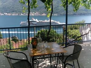 a table and chairs with a cruise ship in the water at Apartments Jovanović in Perast