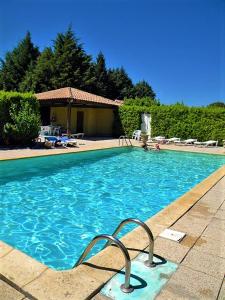 a swimming pool with blue water in a house at Logis Hôtel Restaurant Le Mas De L'Olivier in Pont-Saint-Esprit