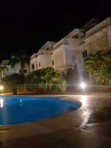 una toma nocturna de una piscina frente a un edificio en La Fenice, Playa Popy, en Las Terrenas