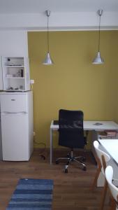 een bureau met een stoel en een koelkast bij Bajta na obzidju in Maribor