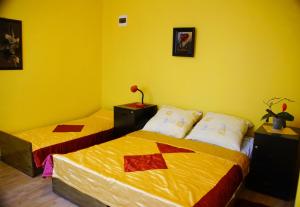 two beds in a room with yellow walls at Wilcza Chata in Kołczewo