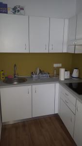 a kitchen with white cabinets and a sink at Bajta na obzidju in Maribor