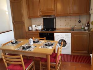a kitchen with a wooden table with chairs and a washing machine at Piazzadarmi 26 in Ancona