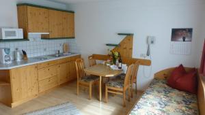 una cucina con tavolo e sedie e una cucina con lavandino di Gästehaus Manuela - Familie Rantner a Seefeld in Tirol