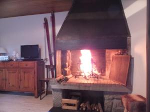 a fireplace with a fire in it in a room at la grange in Formiguères