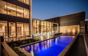 a swimming pool in front of a building at night at StayEasy Maputo in Maputo