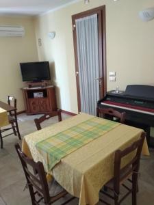 uma sala de estar com uma mesa e um piano em B&B Al Lauro em Asolo