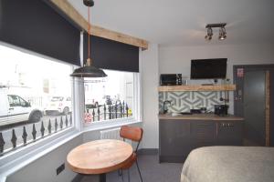 a room with a bed and a table and a window at One Broad Street in Brighton & Hove