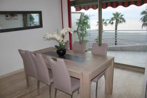 a dining room table and chairs with a view of the ocean at appartement vue mer "le chantilly" cagnes sur mer in Cagnes-sur-Mer