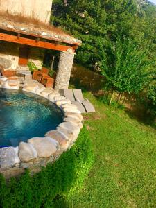 a swimming pool with chairs and a house at U Fragnu in Omessa