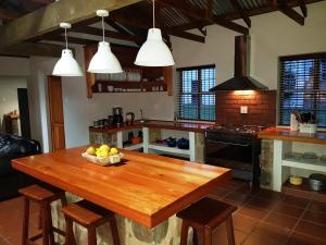a kitchen with a wooden table with a bowl of fruit on it at Koppiesvlei Farm in Tonteldoos