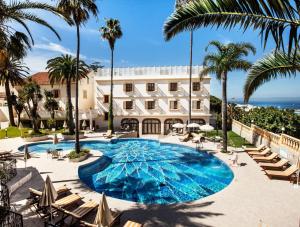 an image of a hotel with a pool and palm trees at Grand Hotel Villa de France in Tangier