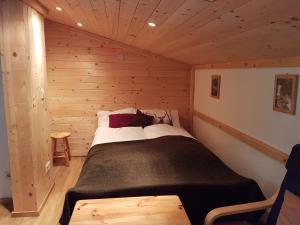 ein Schlafzimmer mit einem Bett in einer Holzhütte in der Unterkunft Apartments Helsen in Mühlbach am Hochkönig