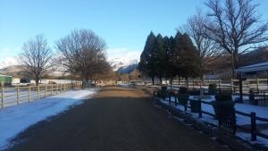 a fence with snow and trees and mountains in the background at First Group Bushman’s Nek in Drakensberg Garden