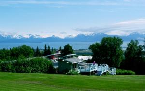 a house in a field with mountains in the background at Halcyon Heights B&B/Inn in Homer