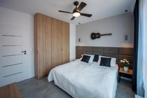 sypialnia z łóżkiem i wentylatorem sufitowym w obiekcie Unique 3City Apartments - Grey Apartment w Gdańsku
