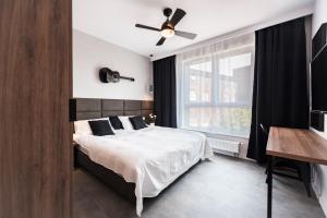 sypialnia z łóżkiem i wentylatorem sufitowym w obiekcie Unique 3City Apartments - Grey Apartment w Gdańsku