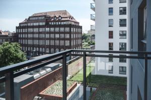 balkon z widokiem na budynek w obiekcie Unique 3City Apartments - Grey Apartment w Gdańsku