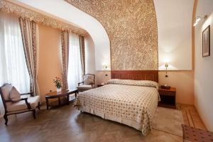 a bedroom with a bed and a chair at Grand Hotel Villa de France in Tangier