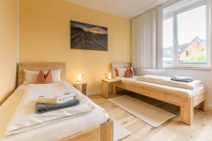 een slaapkamer met twee bedden en een raam bij Hotel Johnsburg in Uelzen