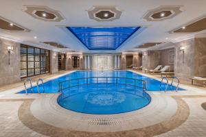 a swimming pool in a building with a blue ceiling at Elite World Istanbul Taksim in Istanbul