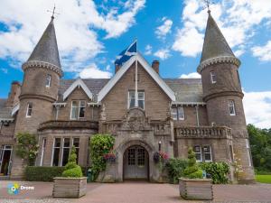 an old castle with a flag on top of it at Ballathie House Hotel in Perth