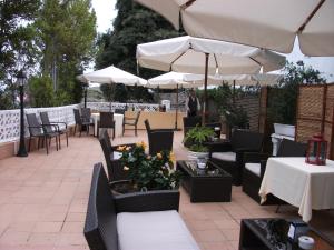 un patio al aire libre con mesas, sillas y sombrillas en Hotel Isla Bella & Spa, en Isla