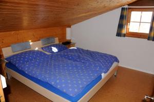 FlumserbergにあるGampergalt - CharmingStayのベッドルーム1室(青い掛け布団、窓付)