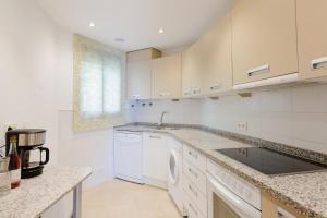 a white kitchen with a sink and a dishwasher at Apartamento Calaceite in Torrox Costa