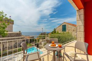 a balcony with a table and chairs and the ocean at Hedera Estate, Villa Hedera V in Dubrovnik